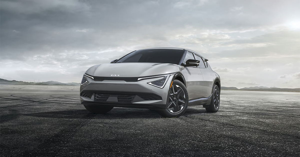 Silver Kia EV6 electric crossover front view on dramatic landscape