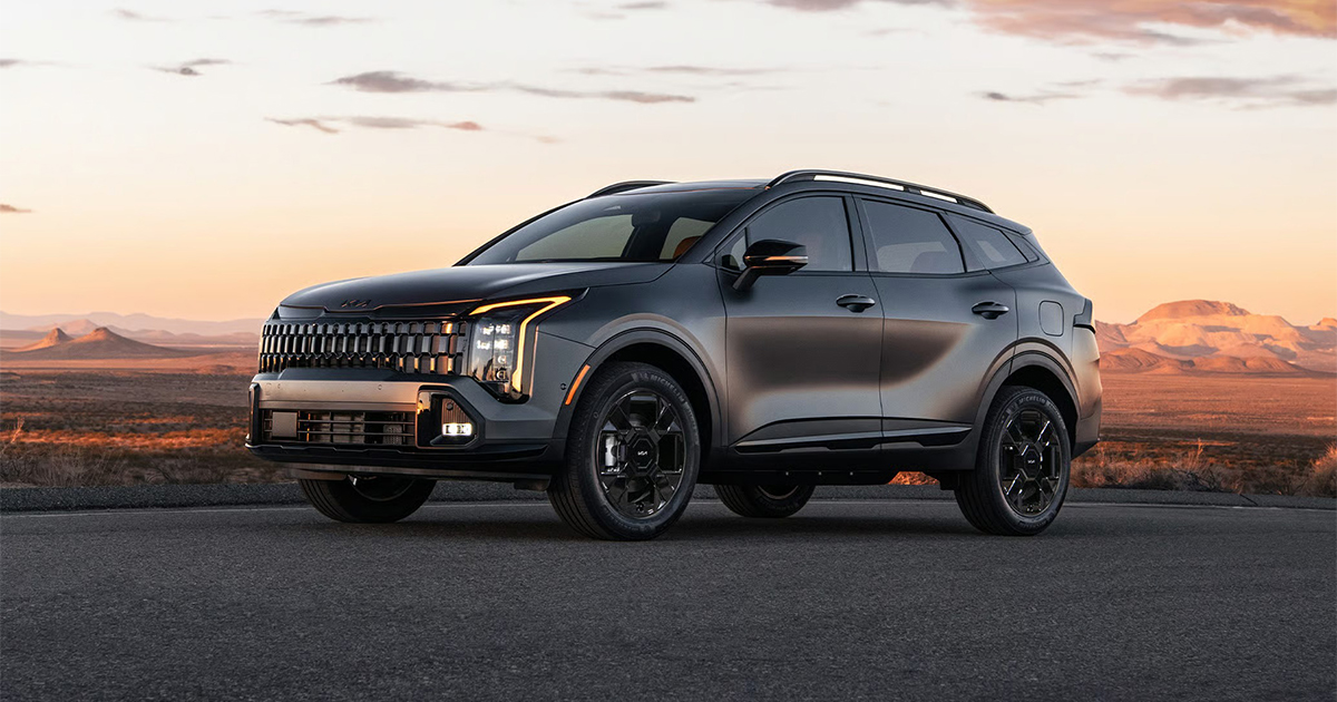 Dark Kia Sportage SUV positioned in desert landscape at golden sunset