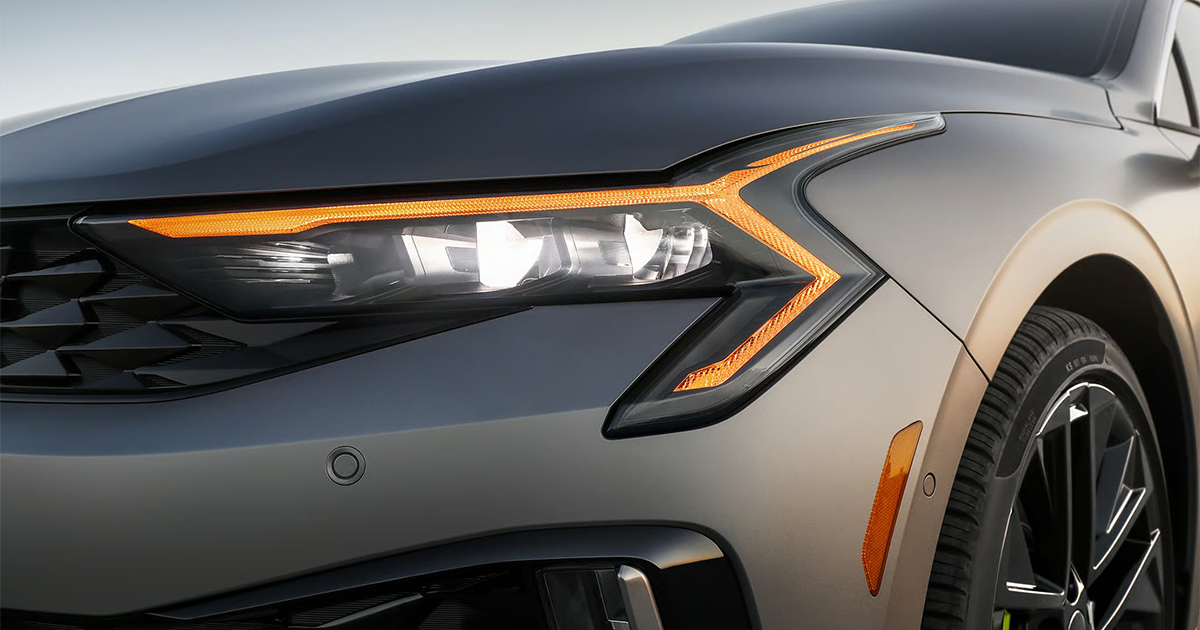 Close-up of Kia K5 sedan LED headlight with amber accent lighting
