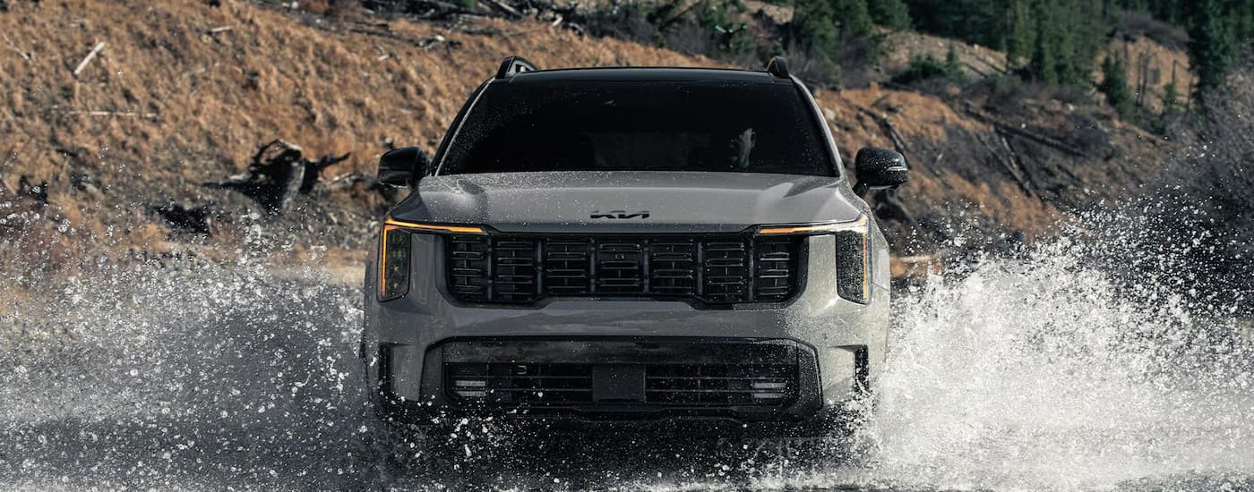 Grey 2026 Kia Sorento off-roading through a river