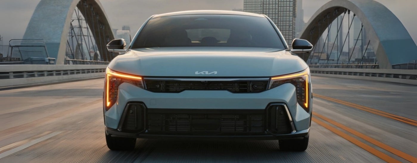 Grey 2025 Kia K4 for sale driving on a bridge