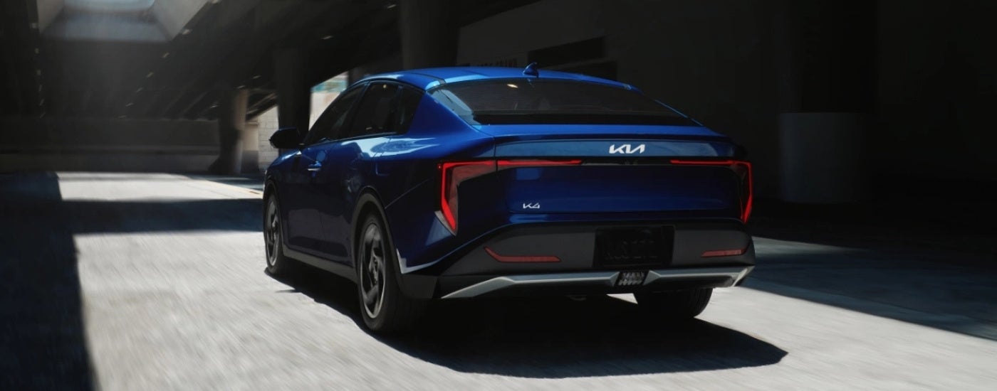 Blue 2025 Kia K4 driving through a parking garage