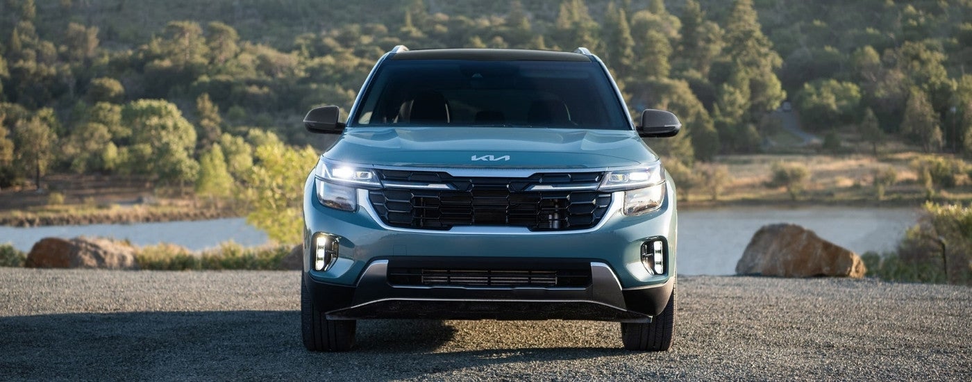 Blue 2025 Kia Seltos for sale parked near a lake