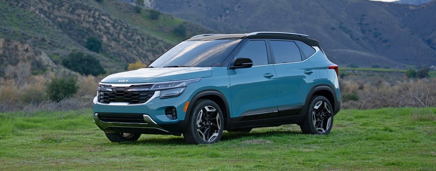 Teal 2024 used Kia Seltos for sale parked on a field
